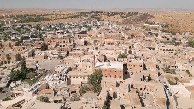 Drone aerial view of Midyat old city in Mardin Province, showing stone houses, narrow streets, historic buildings yellow milestone traditional buildings