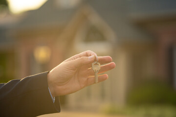 A realtor hands the keys after property purchase. Homeowner holds keys to newly purchased apartment. A real estate agent shows house keys. Client receives keys for a residential property.