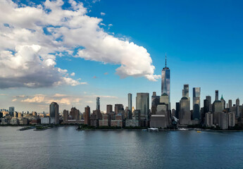 Fototapeta premium NYC aerial skyline, New York. Panorama view of New York city skyscrapers on blue sky. USA NYC. Lower NYC skyline on sunny day. New York cityscape. New York City with clouds from drone.