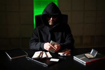 A masked thief steals money from an office during a dark night robbery. A hooded bandit sneaks into...