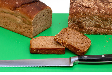 Dark healthy whole grain rye bread cut with knife on board