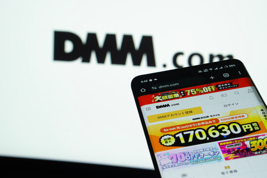 Dhaka, Bangladesh- 03 Oct 2025: Smartphone displaying Dmm.com web interface against Dmm.com logo background.