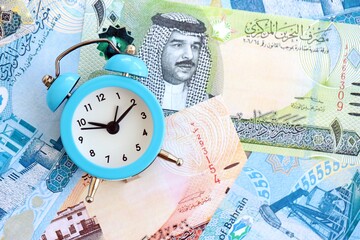 Bahraini dinar currency money bills and alarm clock. The concept of time management and income