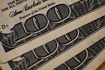Hundred dollar bills stacked close together showcasing intricate detail of currency notes in clear focus