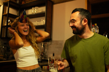 Friends sharing a joyful moment with laughter and celebration in an inviting and cozy indoor setting