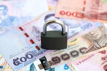 Thai baht currency money bills and padlock. The concept of sanctions and financial safety