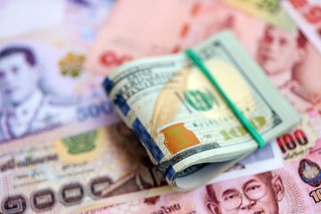 Thai baht currency money bills and bunch of us dollars. The concept of currency exchange
