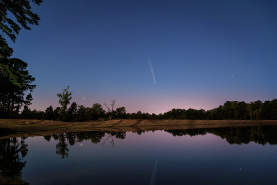 A Comet At Williams Lake with calm water reflections at dusk and blue hour