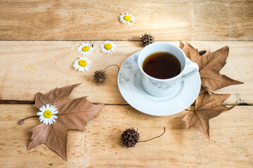 Cup of coffee and white flowers on wooden background