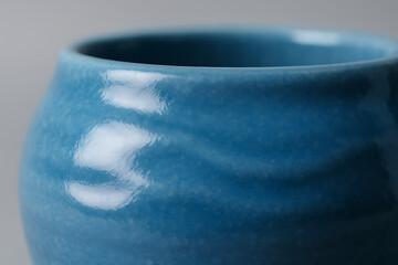 Ceramic Cup Detail: The close-up view reveals the artistry of a blue ceramic cup, highlighting its smooth, glazed surface and the craftsmanship involved in its creation. 