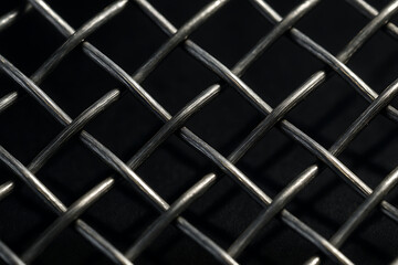 Mesh of Interlaced Metal: A close-up shot reveals a captivating interplay of light and shadow on a meticulously crafted metallic mesh, highlighting its intricate geometric design.