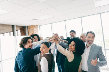 Obraz premium Group of professionals celebrating teamwork with a high-five gesture in a modern office environment