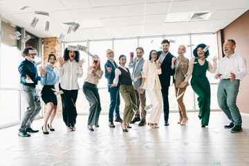 Dynamic office team celebrates success joyfully, diverse group enjoying achievement in a corporate workplace environment