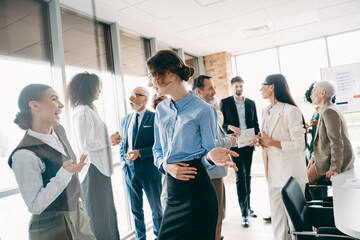 Obraz premium Group of diverse professionals engaged in a meeting inside a modern office space, emphasizing collaboration and productivity