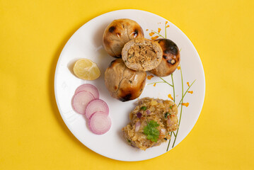 Litti Chokha, the iconic dish of Bihar, is made of wheat balls stuffed with spiced sattu, roasted over fire, and served with mashed potato, brinjal, and tomato. It’s a rustic, flavorful, and cultural 