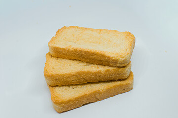 Three golden-brown, crispy Indian toast biscuits, commonly known as rusks, are neatly stacked on a clean white studio background.