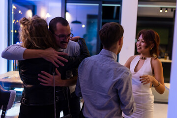 Group of friends enjoying a social evening gathering with smiles and embraces