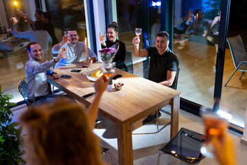 Group of friends celebrating with a toast and wine during a festive indoor gathering