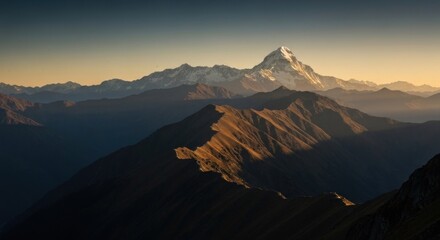 Mountain peak, snowy top, and rugged, lower ridge line highlighted by golden light