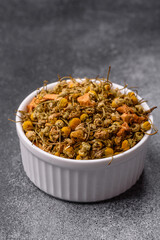 Dried chamomile flowers, herbal tea in a bowl for a hot morning drink. Dried chamomile