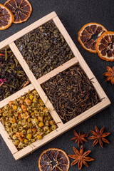 A wooden box with several types of dried tea, green, black, fruit, and chamomile. Dry tea in the box