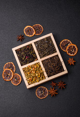 A wooden box with several types of dried tea, green, black, fruit, and chamomile. Dry tea in the box