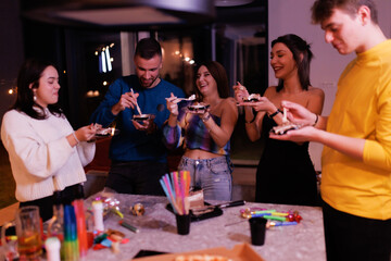 Group of young friends enjoying dessert together at a festive indoor party