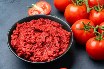 Fresh tomato paste or puree on black background	