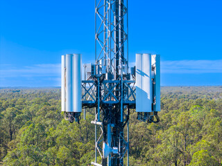 Drone aerial photograph of the top section of a large Telecommunications Tower located in a residential area amongst lush bushland in regional NSW, Australia.