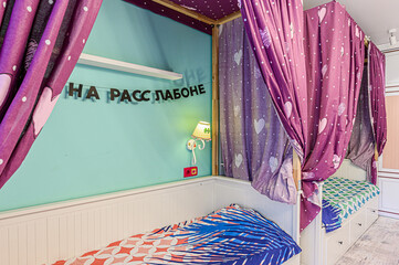 Whimsical bedroom with twin beds under a curtained canopy