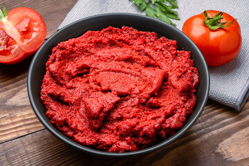 Fresh tomato paste or puree on wooden background	