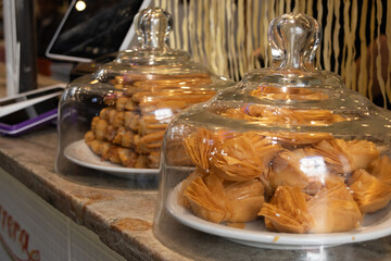 Two transparent containers on a counter with different snacks from the refined pastry shop