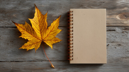 Autumn-themed mockup featuring a single notebook page isolated on rustic wood with a dry maple leaf in the corner and soft warm shadows.