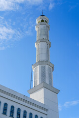 Mosque minaret rising against a bright blue sky, symbolizing Islamic architecture and serving multiple functions as a call to prayer tower, cultural landmark, and architectural heritage.