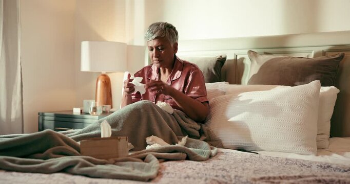 Sneeze, blowing nose and senior woman in bed with allergies, flu or cold on weekend morning in home. Illness, sick and mature female person in retirement with tissue for sinus in bedroom at house