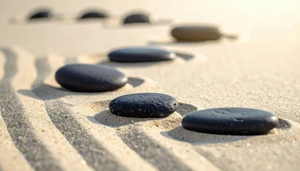 Acrylglasbilder Steine​ im Sand Black stones arranged on sand in a minimalist zen scene  © NurStock