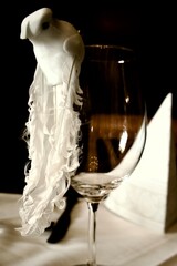 White decorative dove made of fabric and feathers attached to a wine glass, symbolizing love and peace at a wedding celebration table.