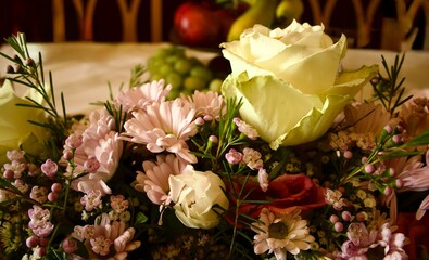 Bouquet of white roses, soft pink chrysanthemums, and small flowers with greenery, beautifully arranged for a festive table at a special celebration.