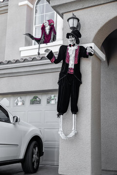 Spooky skeleton dressed in black suit hanging on the wall for Halloween celebration, USA