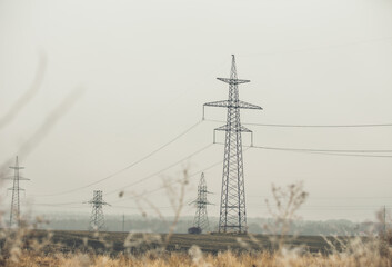 High Voltage Poles or Electric tower is transmission high voltage power locate on green field - Energy technology concept