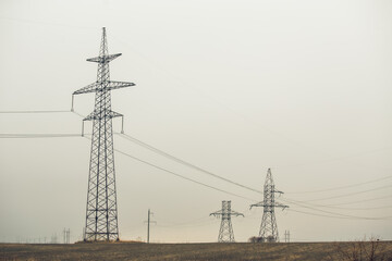 High Voltage Poles or Electric tower is transmission high voltage power locate on green field - Energy technology concept