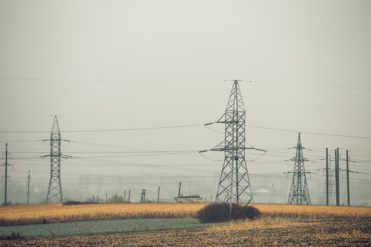 High Voltage Poles or Electric tower is transmission high voltage power locate on green field - Energy technology concept - Powered by Adobe