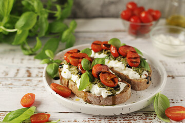 Italian sandwiches with grilled tomatoes, burrata cheese and pesto