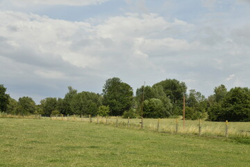Fototapeta premium paysage rural sous un ciel gris entrecoupé d'éclaircies à Ghislenghien (Ath)