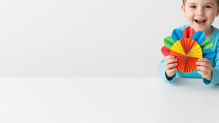 Smiling child making paper turkey craft on white table background (copy space)