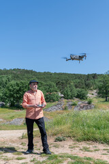 Man operating drone with remote control in nature