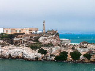 Alcatraz Island in San Francisco Bay features a historic prison, iconic lighthouse, rugged cliffs,...