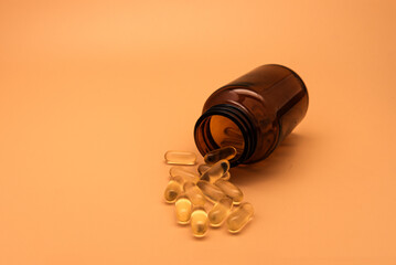 Brown Bottle with Softgel Capsules on Minimalist Orange Background