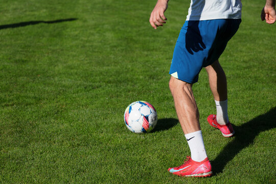 Cesky Dub, Czechia - September 28, 2025. Soccer and football player with muscular legs and big calves is going to kick the ball. Man is wearing Nike shoes and socks. Copy space. Shallow focus.