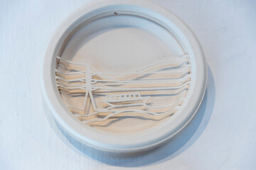 Layered papercut art in a circular frame, depicting a minimalist landscape with a boat and telephone pole on the water.